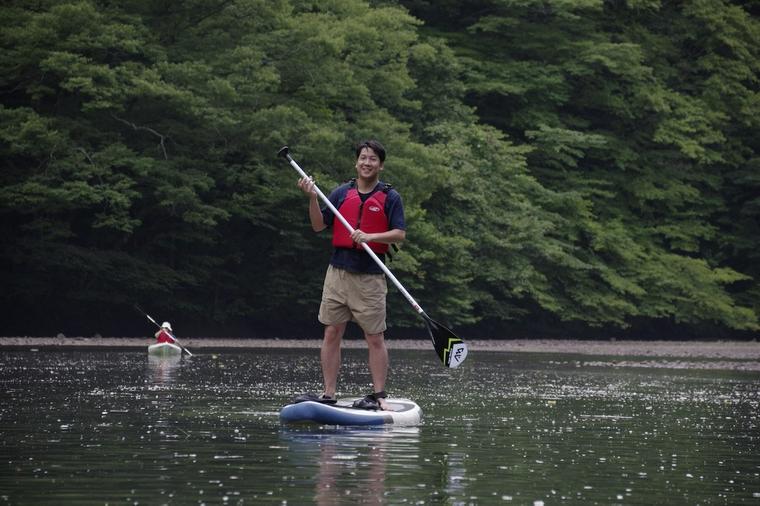 SUPのボードに座る犬