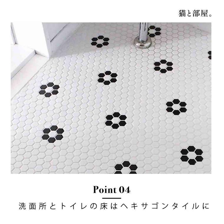 白地に黒い花柄のヘキサゴンタイルの床